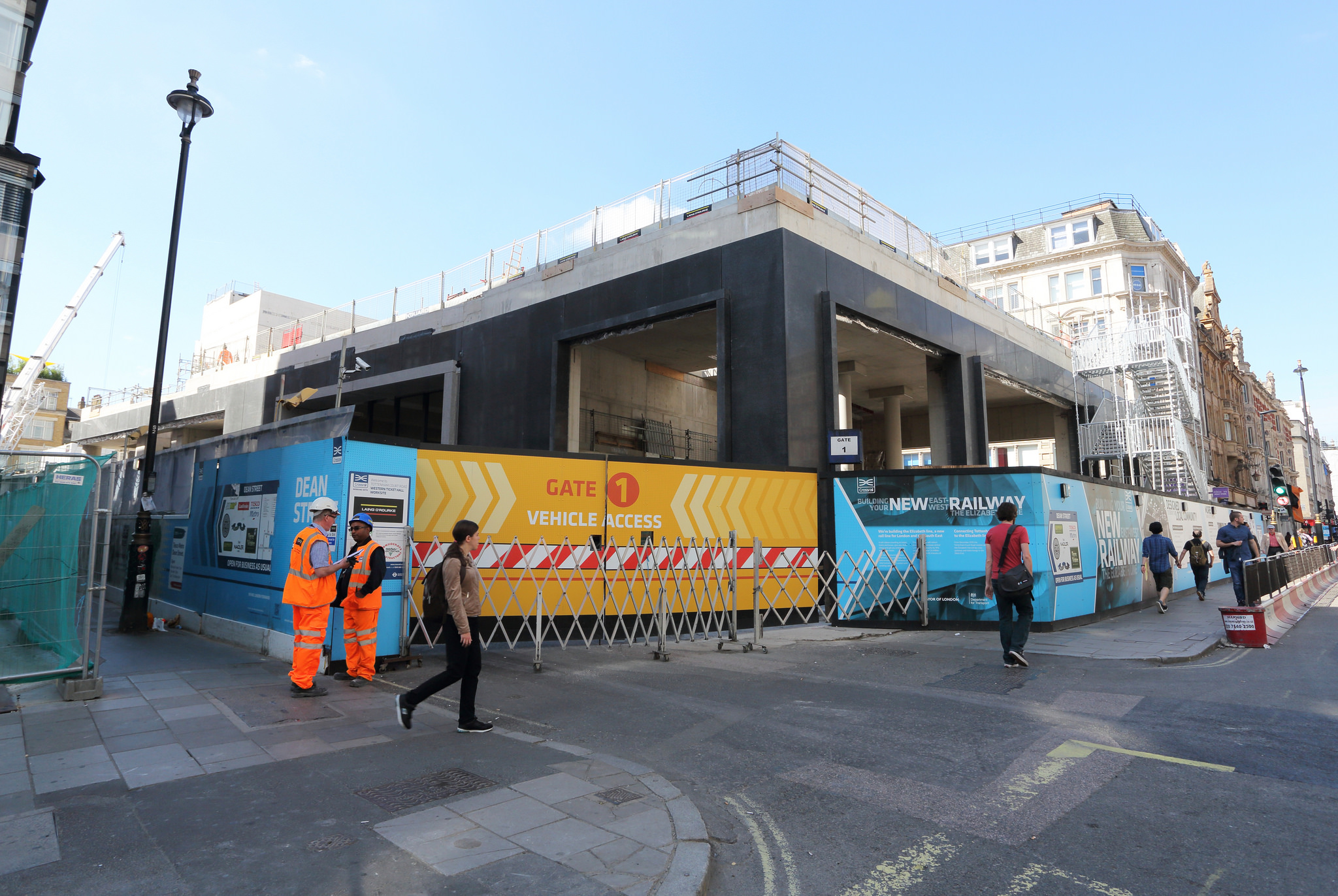 Photo of Dean Street worksite from Oxford Street showing site hoardings including vehicle access gate