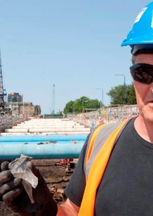 Photo of a worker at North Woolwich Portal worksite holding a piece of excavated rock